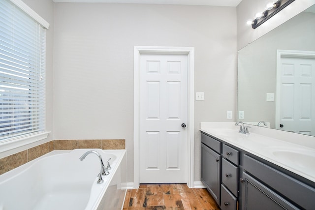 bathroom with vanity, hardwood / wood-style floors, and a tub