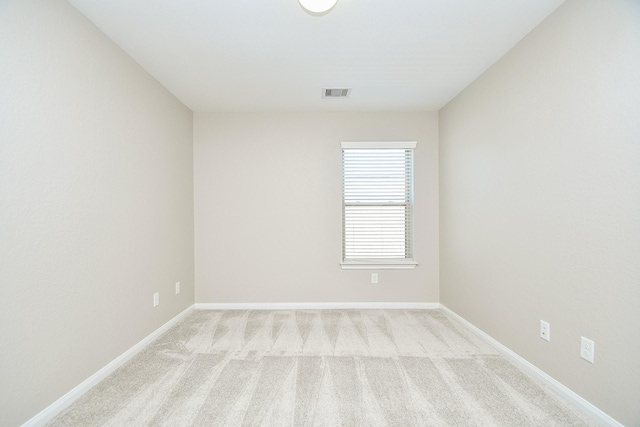 spare room featuring light carpet