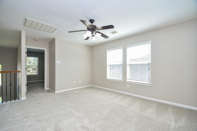 spare room featuring light carpet and ceiling fan