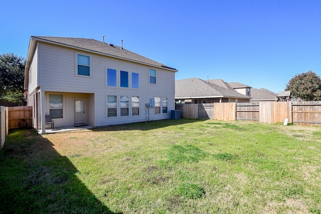 back of house featuring a yard and central AC unit