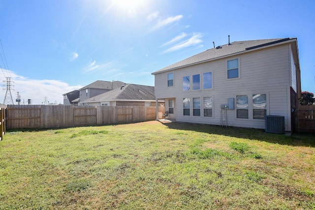 back of house featuring cooling unit and a lawn