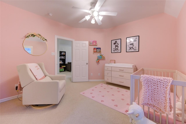 bedroom with ceiling fan, lofted ceiling, light colored carpet, baseboards, and a crib