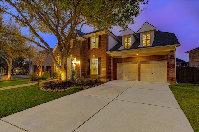 view of front facade featuring an attached garage, brick siding, fence, driveway, and a lawn