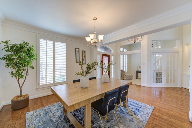 dining room with baseboards, light wood-type flooring, an inviting chandelier, and crown molding