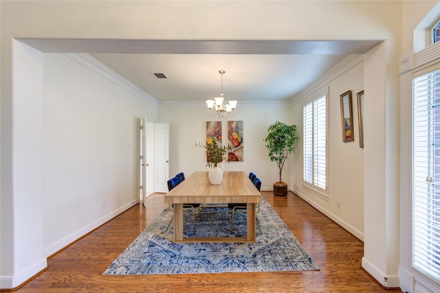 dining area with baseboards, visible vents, dark wood finished floors, crown molding, and a notable chandelier