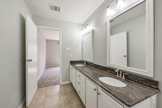 bathroom featuring vanity, tile patterned floors, and a textured ceiling