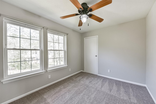 carpeted spare room with ceiling fan