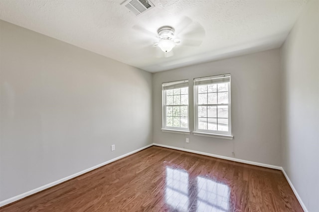 spare room with ceiling fan, hardwood / wood-style floors, and a textured ceiling