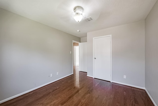 unfurnished bedroom featuring dark hardwood / wood-style floors and a closet