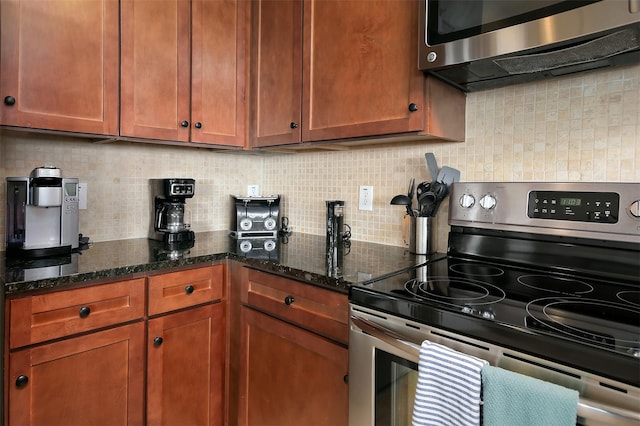 kitchen featuring stainless steel appliances, tasteful backsplash, and dark stone counters