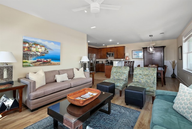 living room featuring ceiling fan and light wood-type flooring