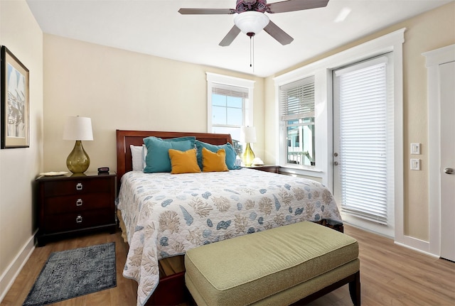 bedroom featuring hardwood / wood-style flooring, ceiling fan, and access to outside