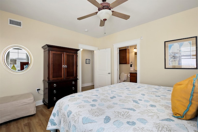 bedroom with dark wood-type flooring, ceiling fan, and ensuite bathroom