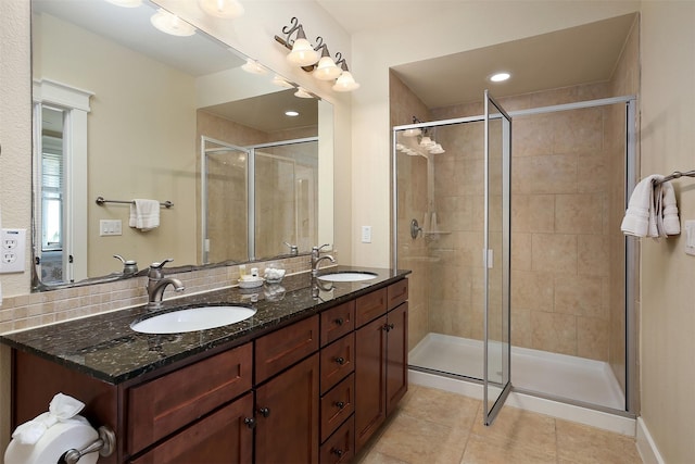 bathroom with tile patterned floors, a shower with door, and vanity