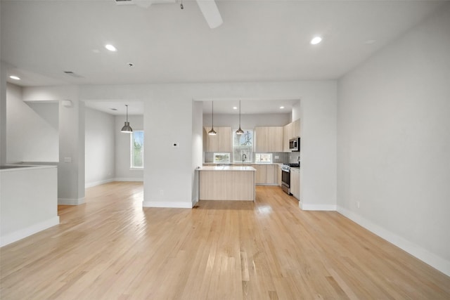 unfurnished living room with ceiling fan and light wood-type flooring