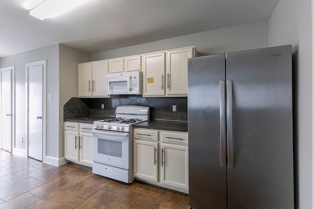 kitchen with tasteful backsplash, white appliances, and white cabinets