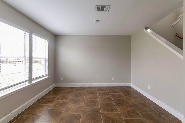 unfurnished room featuring dark tile patterned floors