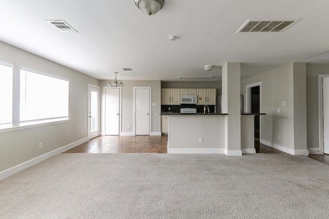 unfurnished living room featuring light carpet and a chandelier