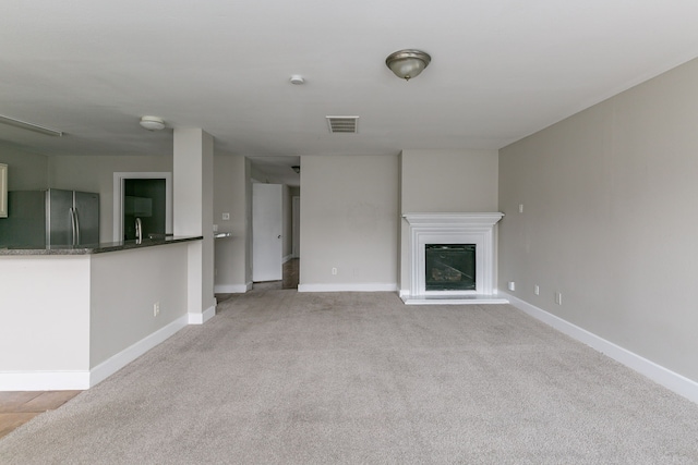 unfurnished living room featuring light carpet