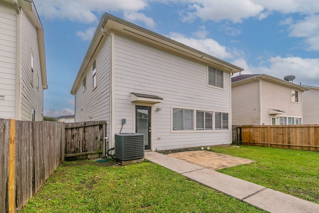 rear view of property featuring a yard, a patio area, and central air condition unit