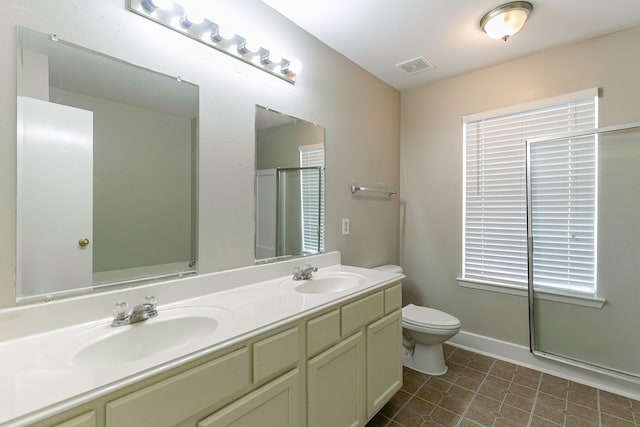 bathroom featuring a shower with door, vanity, tile patterned flooring, and toilet