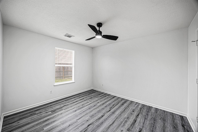 spare room with baseboards, visible vents, dark wood finished floors, ceiling fan, and a textured ceiling