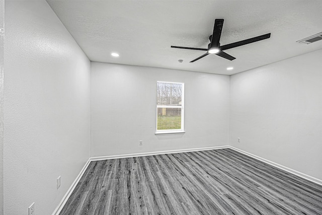 spare room featuring a textured ceiling, wood finished floors, visible vents, and baseboards