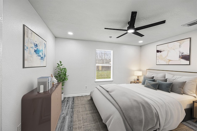 bedroom featuring visible vents, dark wood finished floors, a textured ceiling, and baseboards