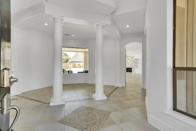 interior space featuring tile patterned flooring, ornamental molding, and decorative columns