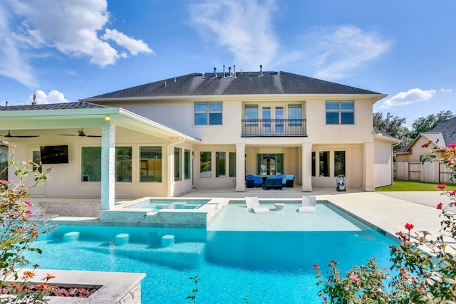 rear view of property with ceiling fan, a swimming pool with hot tub, outdoor lounge area, and a patio area