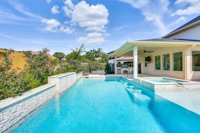 view of pool featuring an in ground hot tub, ceiling fan, and an outdoor kitchen