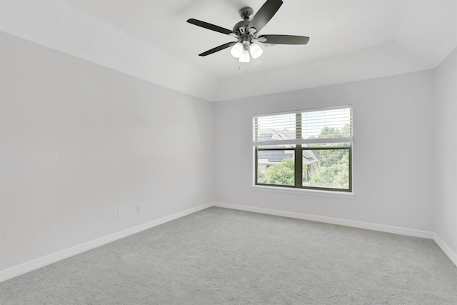 carpeted empty room with ceiling fan and a tray ceiling