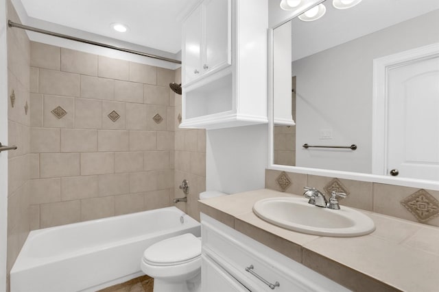 full bathroom with tiled shower / bath combo, vanity, and toilet