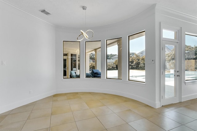 unfurnished dining area with crown molding, light tile patterned flooring, and a chandelier