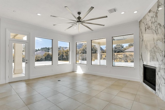 unfurnished sunroom featuring ceiling fan and a fireplace