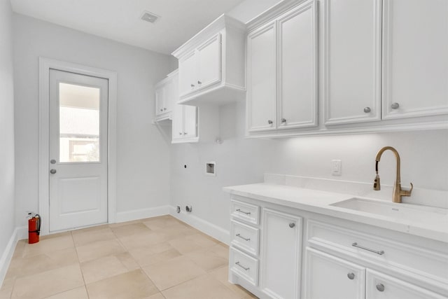 laundry area featuring sink, light tile patterned floors, electric dryer hookup, hookup for a washing machine, and cabinets