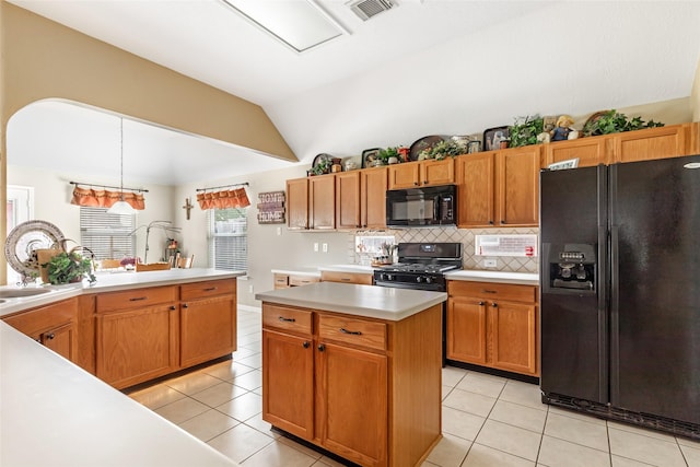 kitchen with visible vents, light countertops, black appliances, vaulted ceiling, and light tile patterned flooring