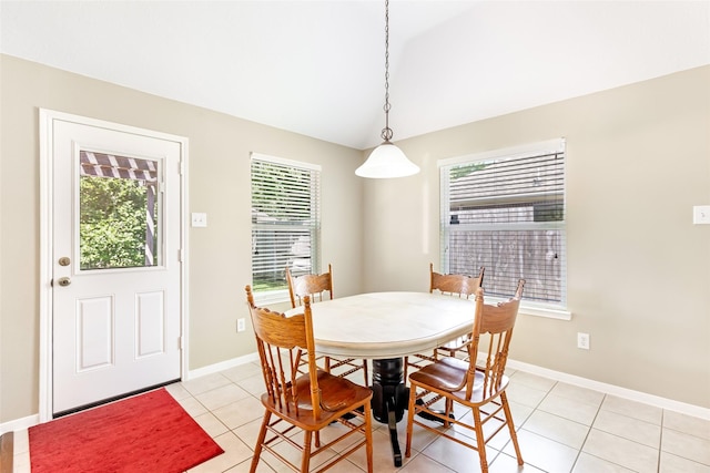 dining space featuring baseboards, vaulted ceiling, and light tile patterned flooring