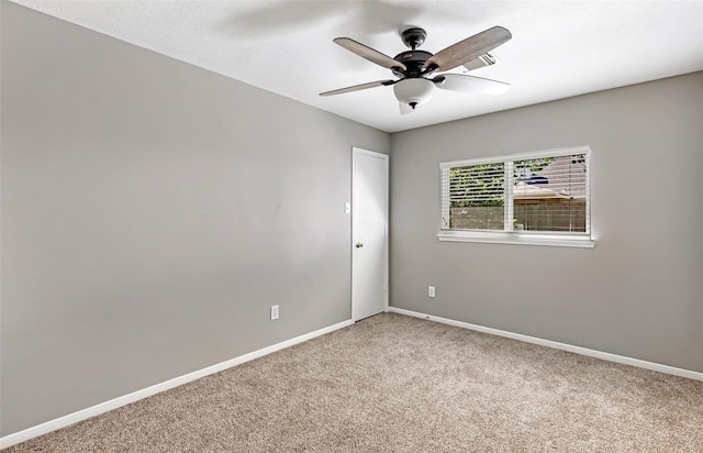 empty room with light colored carpet, ceiling fan, and baseboards