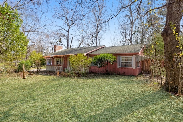 view of side of property featuring a chimney and a yard