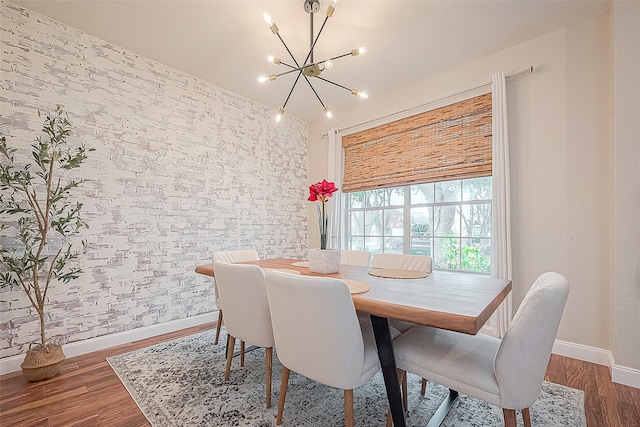 dining space with dark wood-type flooring and a notable chandelier