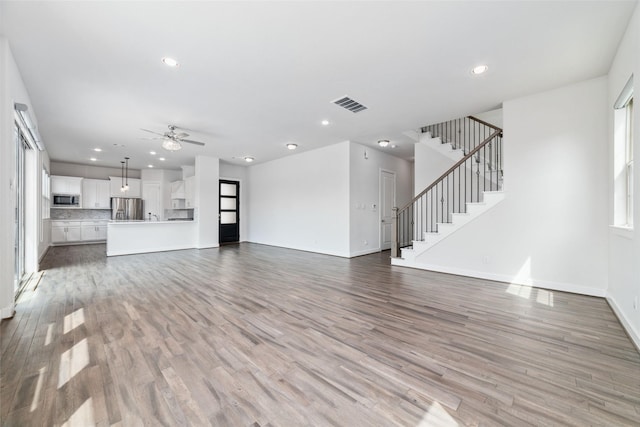 unfurnished living room featuring ceiling fan and light hardwood / wood-style floors