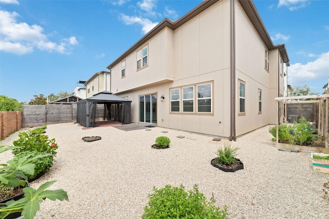 back of property with a gazebo and a patio area