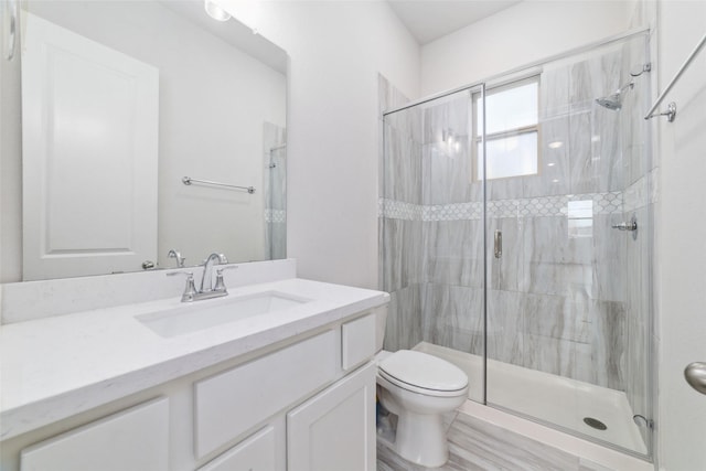 bathroom featuring vanity, toilet, and walk in shower