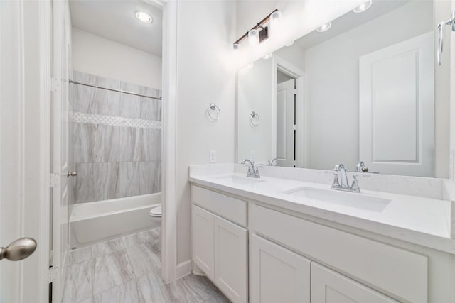 full bathroom with vanity, toilet, and tiled shower / bath