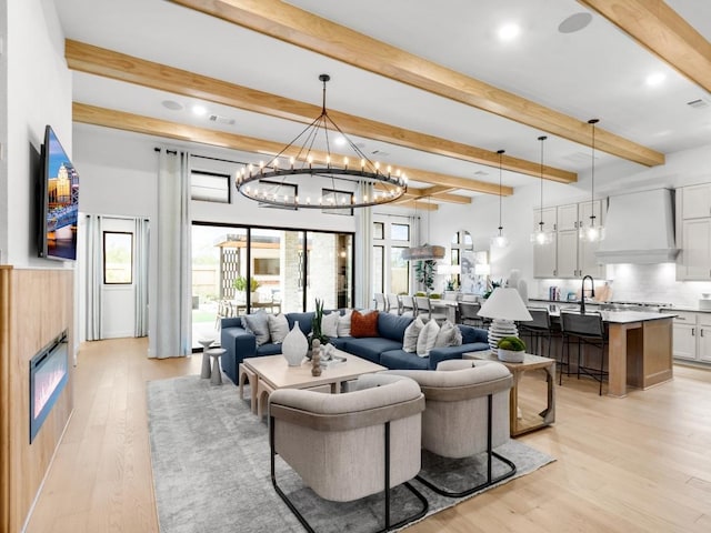 living room featuring beam ceiling and light hardwood / wood-style floors