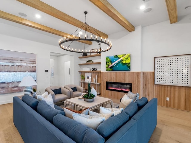 living room with beam ceiling, light wood-type flooring, and wood walls