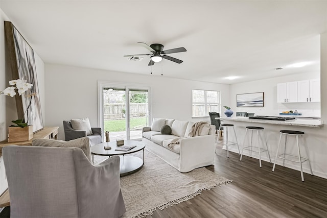 living room with dark wood-type flooring and ceiling fan