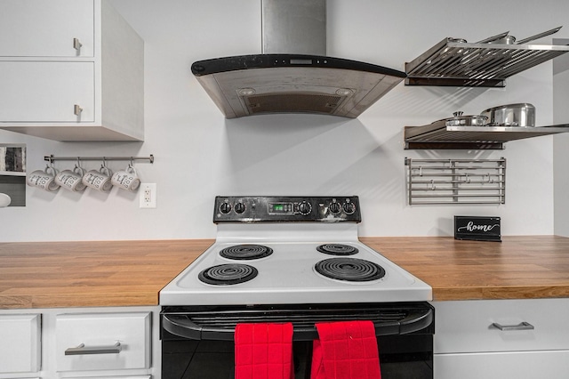 kitchen with electric stove, butcher block countertops, white cabinetry, and island range hood