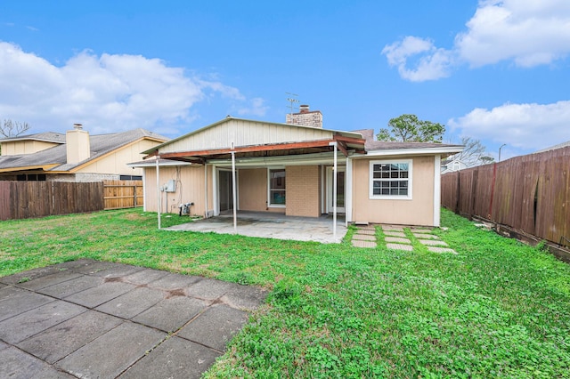 rear view of house featuring a yard and a patio area